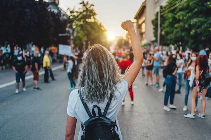 Portrait of person at demonstration, with arm raised