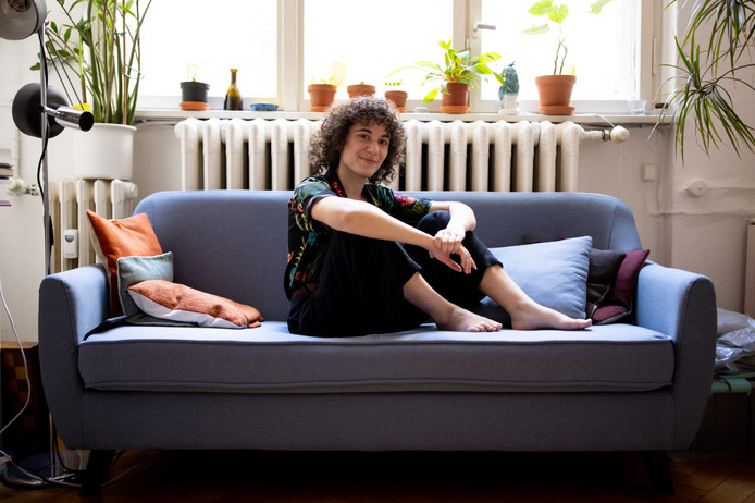 Non-binary person sitting on sofa